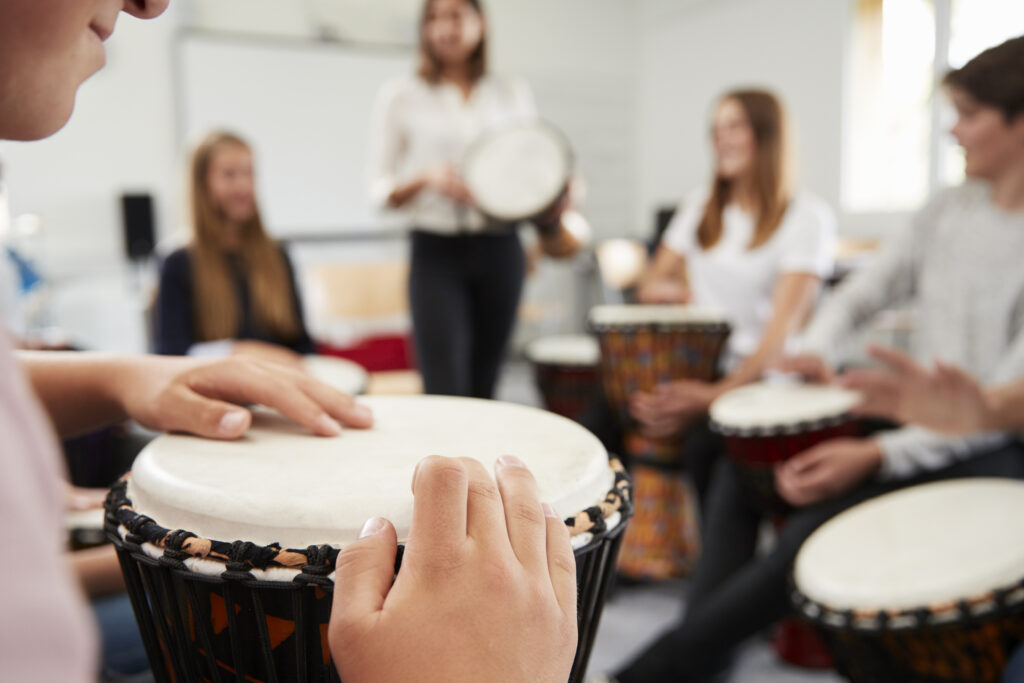 students participating in group drumming activity
